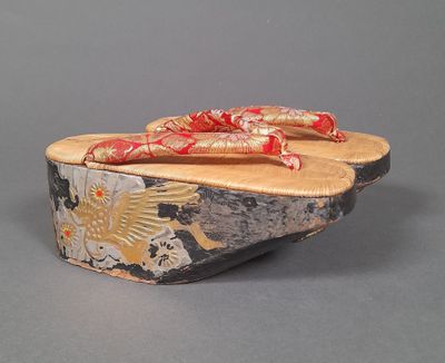 un sabot en bois orné d'un ruban rouge sur le dessus