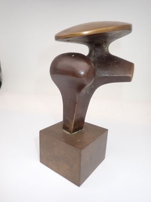 a bronze sculpture of a bird on a wooden base