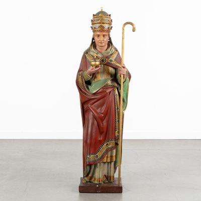 a statue of a man holding a staff and wearing a crown