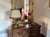 a dresser with a mirror and a lamp on top of it