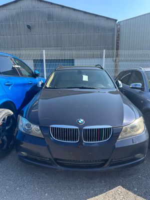 deux voitures garées devant un immeuble, avec une voiture bleue au premier plan