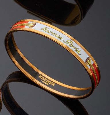 three different colored bang bracelets on a black surface with reflection