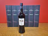 une bouteille de vin posée sur une table à côté d'une pile de livres