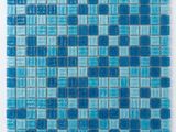 un gros plan d'un carreau de mosaïque en verre bleu sur une surface blanche