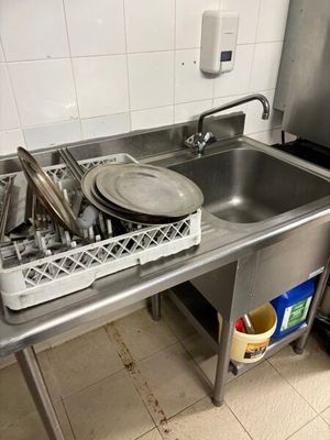 un évier en inox contenant de la vaisselle et des ustensiles