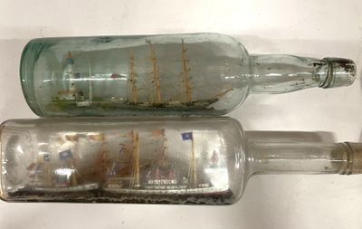 two empty glass bottles that are sitting on a table
