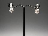 a pair of black and white earrings on a black stand