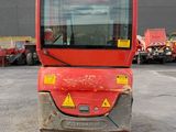 an image of a small red vehicle parked in a parking lot