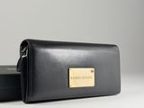 a black leather wallet with a gold plate on the front