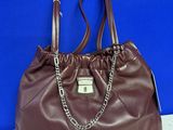 a brown purse with a chain on the handle