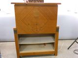 a person standing next to a small wooden cabinet