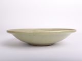 a green bowl sitting on a white surface