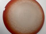 a picture of a red and white plate on a white table