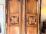 une grande armoire en bois dans une pièce au sol carrelé