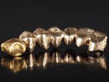 un gros plan sur une dent en or et une brosse à dents en or