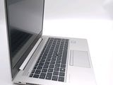 a silver laptop with a black keyboard on a white surface
