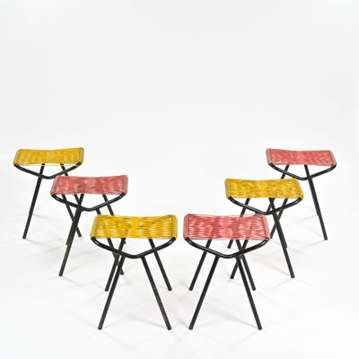 four stools with yellow, red, and yellow fabric on them