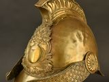 helmet of a roman soldier with a golden helmet on a metal stand