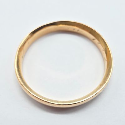 gros plan d'une bague en or sur une surface blanche