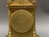 a gold clock sitting on top of a white table