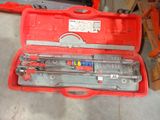 une caisse à outils rouge avec des outils sur le sol