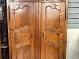 a large wooden armoire in the corner of a room