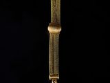 an image of a close up of a gold watch on a black background