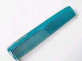 a blue comb sitting on top of a white table