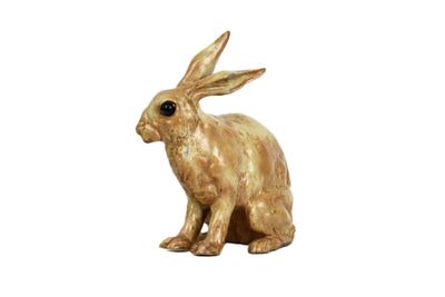 une petite statue représentant un lapin assis sur une surface blanche