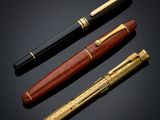 three different types of pens on a black background