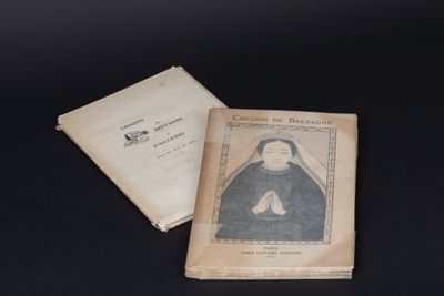 un vieux livre posé sur une table noire, à côté d'un autre livre
