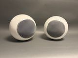 pair of white speakers sitting on top of each other on a gray surface