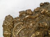 une statue en or représentant un lion avec un bouclier sur le dos