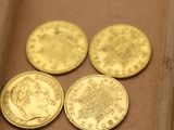 Il y a quatre pièces d'or dans une boîte posée sur une table