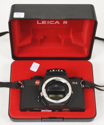 a black camera in a red case on a white surface