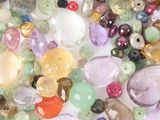 a lot of different colored beads on a white surface