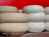many white vases on a shelf in a red room