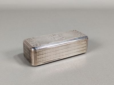 une boîte argentée posée sur une table, sur fond blanc
