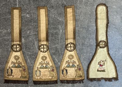 three wooden spoons with embroidered designs on them sitting on a table
