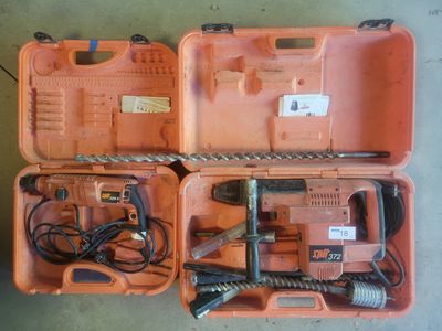 une mallette orange contenant des outils, posée par terre