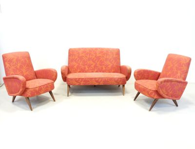 three chairs and a couch in a room with a white wall