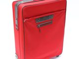 une valise rouge posée sur une surface blanche