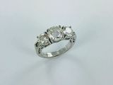 a three stone diamond ring on a white background
