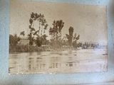 an old photo of a river with trees in the background
