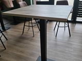 des tables et des chaises dans une pièce avec une grande fenêtre en arrière-plan