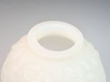 a white vase that is sitting on a table