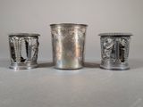 three silver cups sitting next to each other on top of a table
