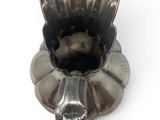 a silver vase that is shaped like a flower