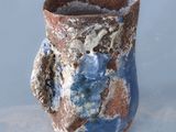 a blue and brown vase sitting on top of a table
