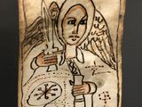 painting of an angel holding a sword and a shield on a piece of paper